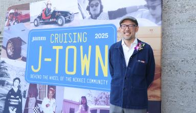 Oliver Wang standing next to Cruising J-Town banner